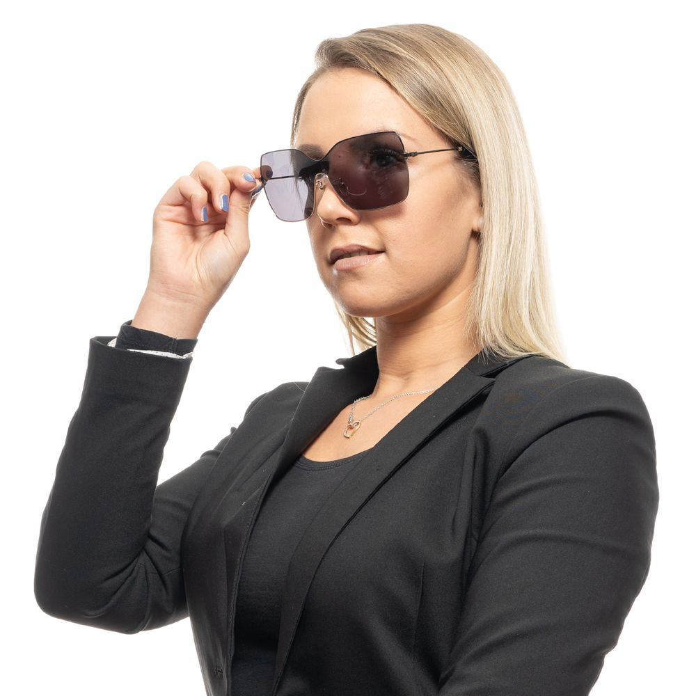 Woman wearing Carolina Herrera black sunglasses with grey lenses and metal frame, offering 100% UVA & UVB protection.