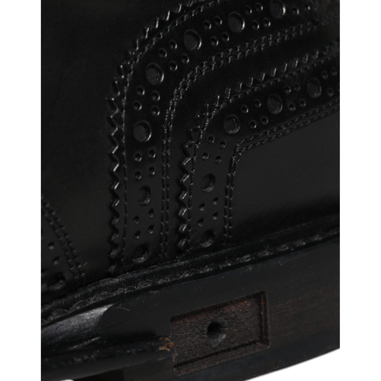 Close-up of Dolce & Gabbana black leather derby wingtip formal shoe detailing, showing intricate craftsmanship and missing logo.