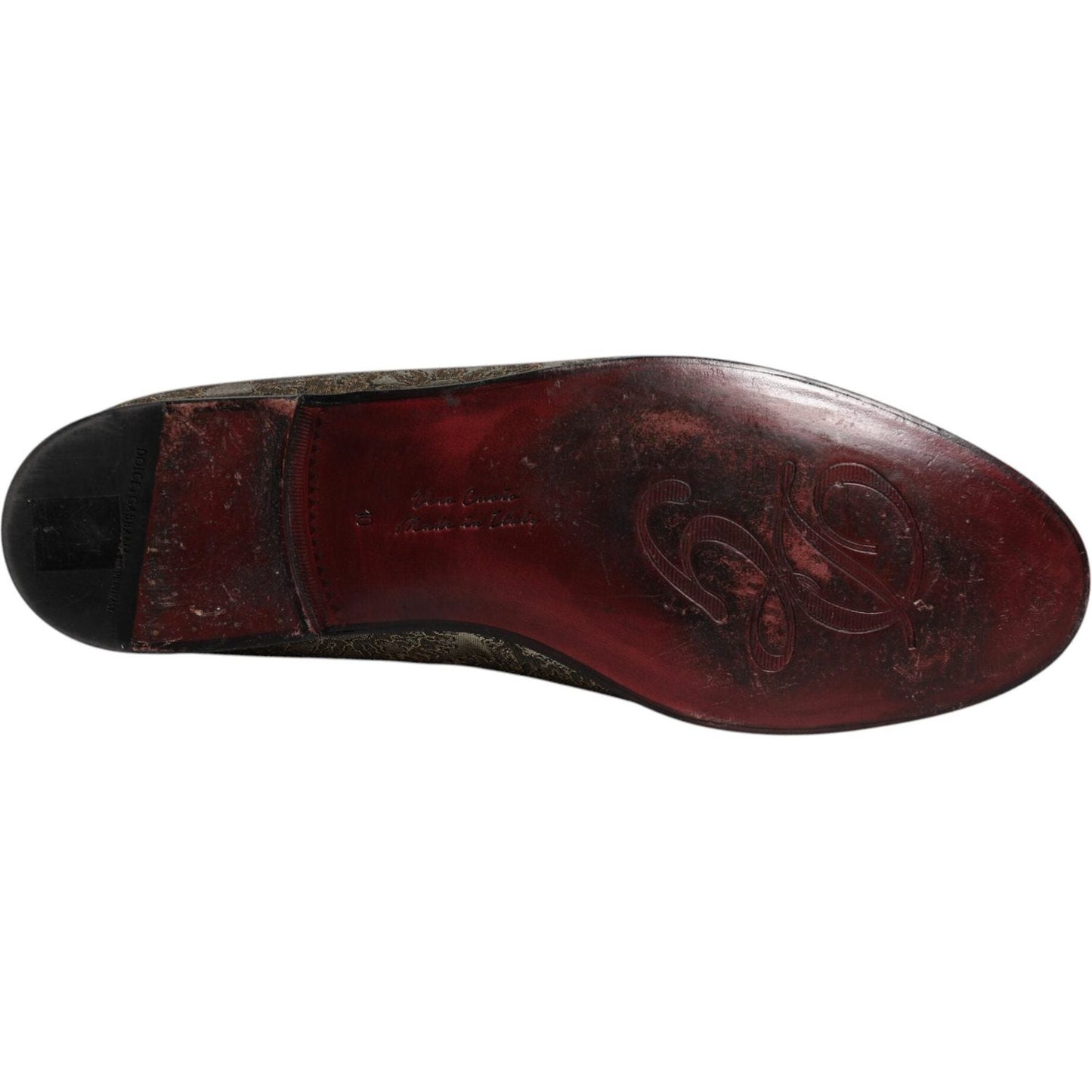 Sole view of Dolce & Gabbana gold jacquard loafers with embossed logo, Bordeaux leather, made in Italy, showing minor marks.