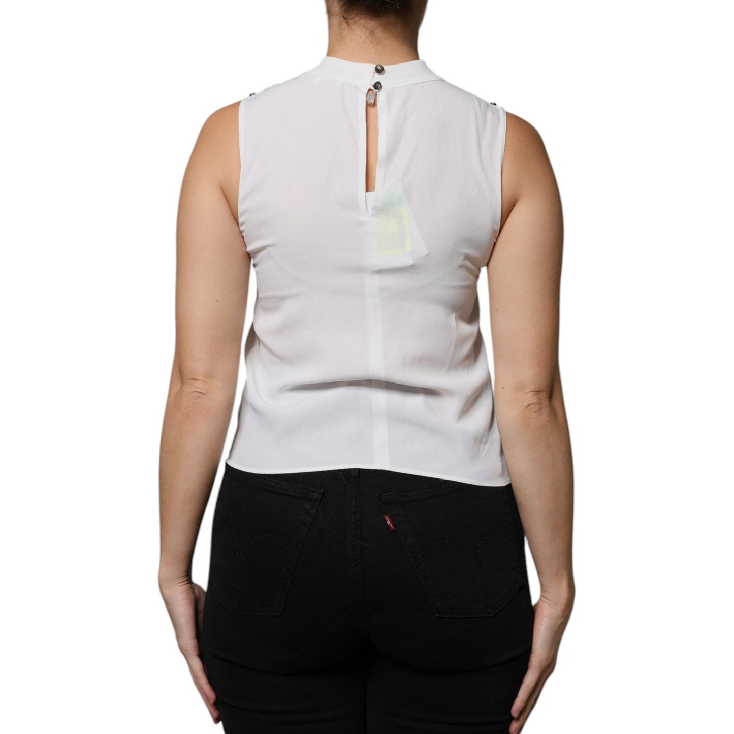 Back view of Patrizia Pepe white sleeveless tank blouse with mock neckline and button closure, worn by model.