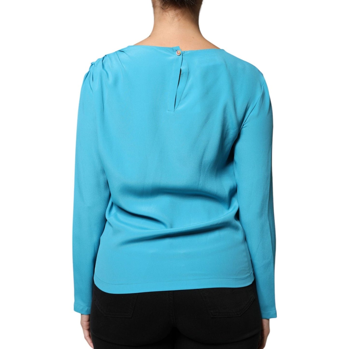 Back view of Boutique Moschino blue blouse with round neckline, long sleeves, and back button closure, showing minor pulled threads.
