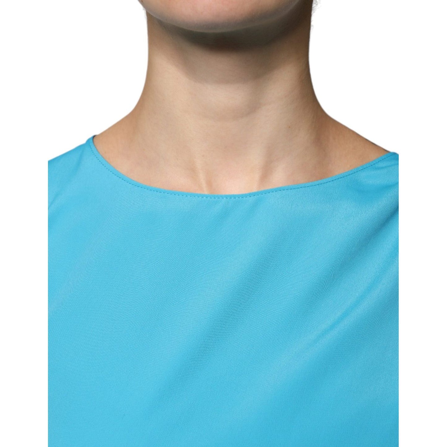 Boutique Moschino blue round neckline blouse with long sleeves, showing smooth fabric and elegant design.