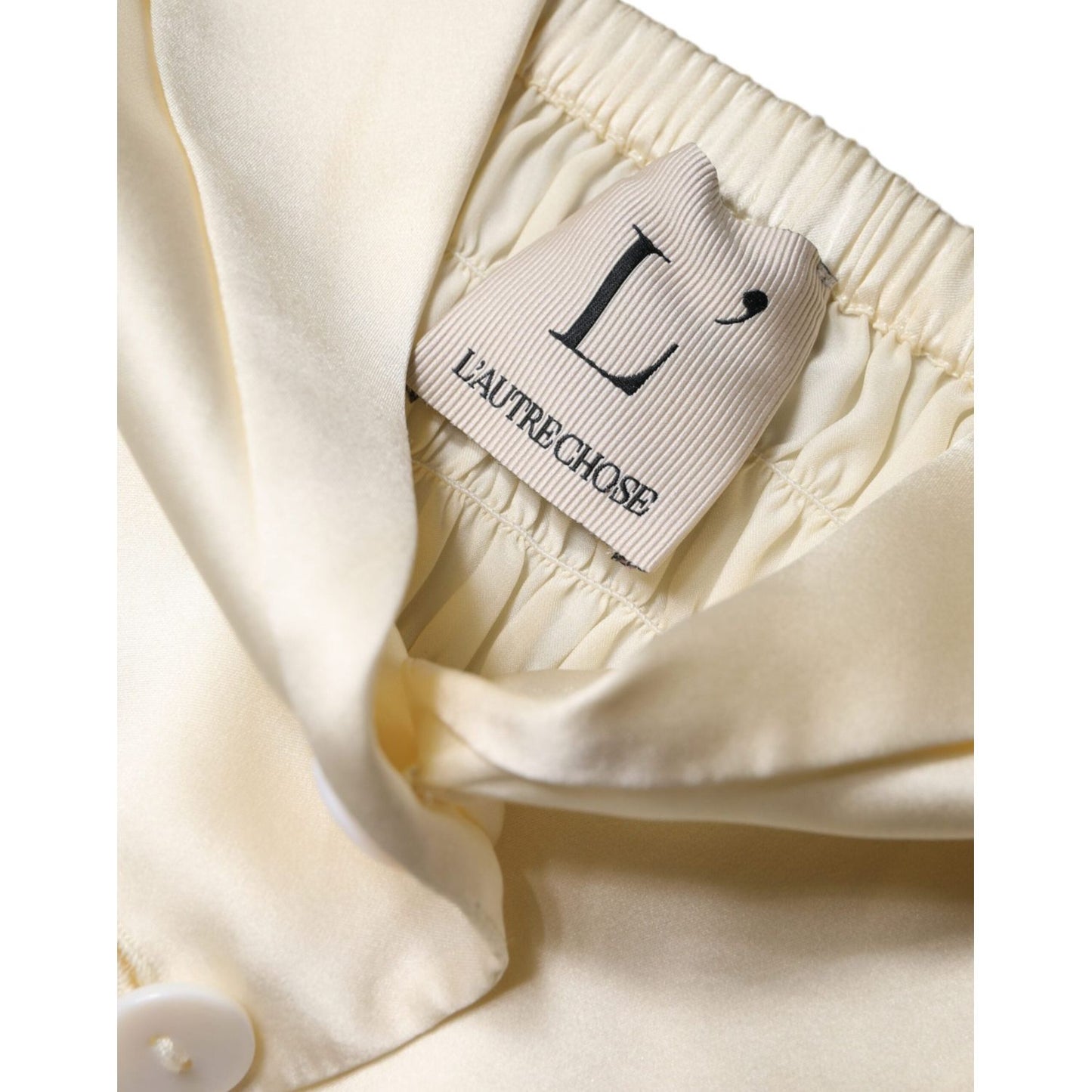 L'Autre Chose off white silk halter top with button detail and visible logo tag on the inside, highlighting luxury Italian design.