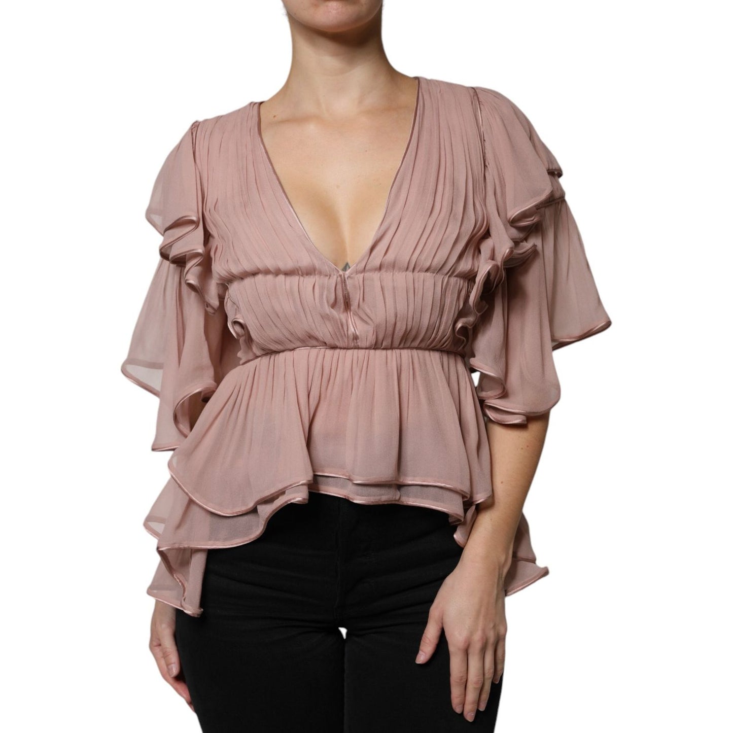 Model wearing a pink pleated V-neck blouse with short sleeves.
