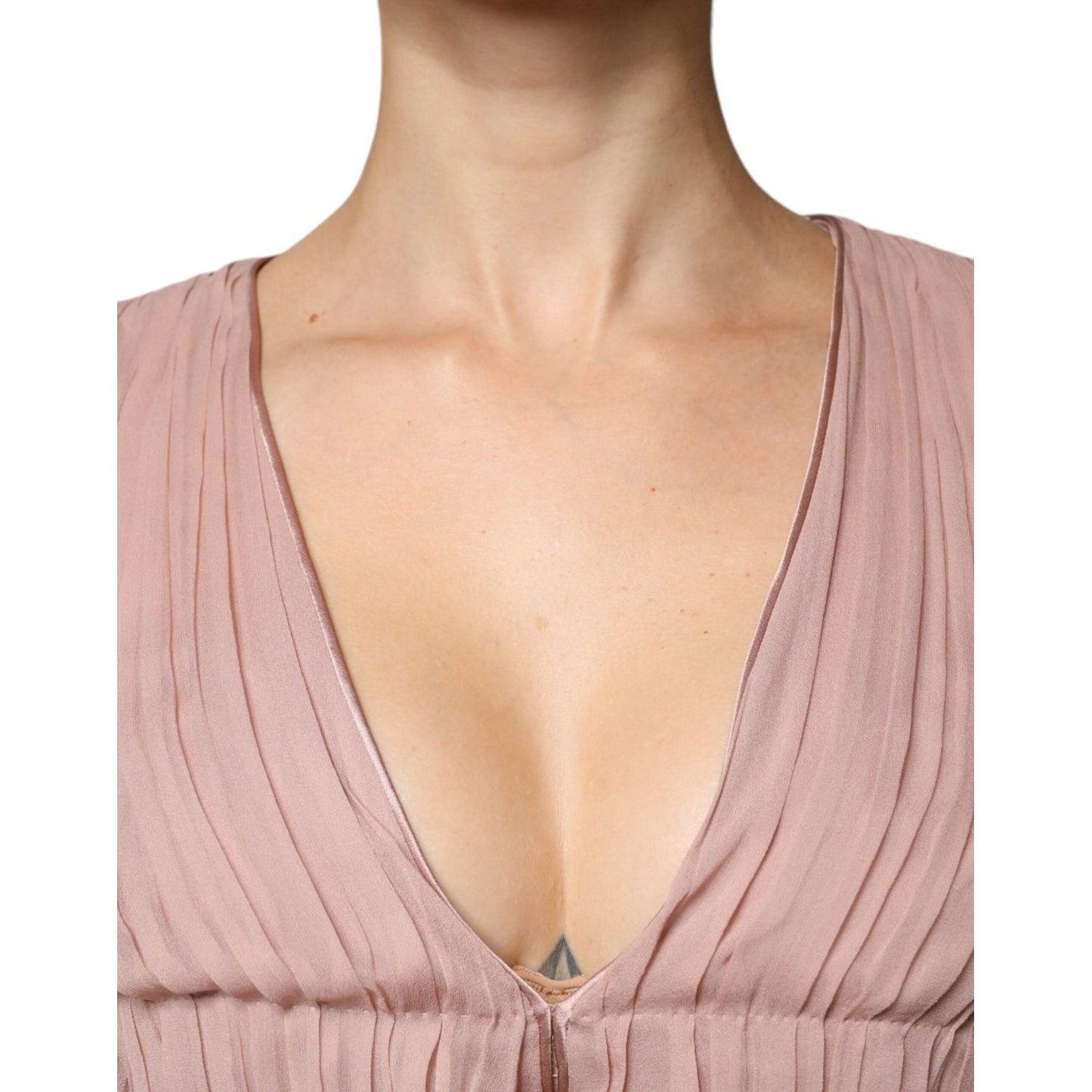 Close-up of a pleated V-neck top in soft brown silk, showcasing elegant design and texture.