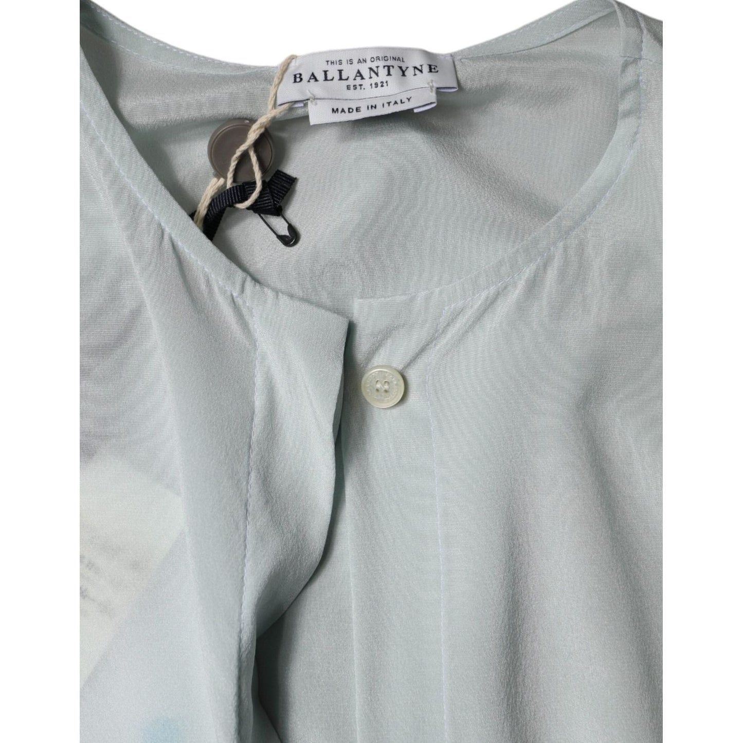 Light blue Ballantyne silk top with ascot collar and button closure, showing label detail, made in Italy, minor stain on back.