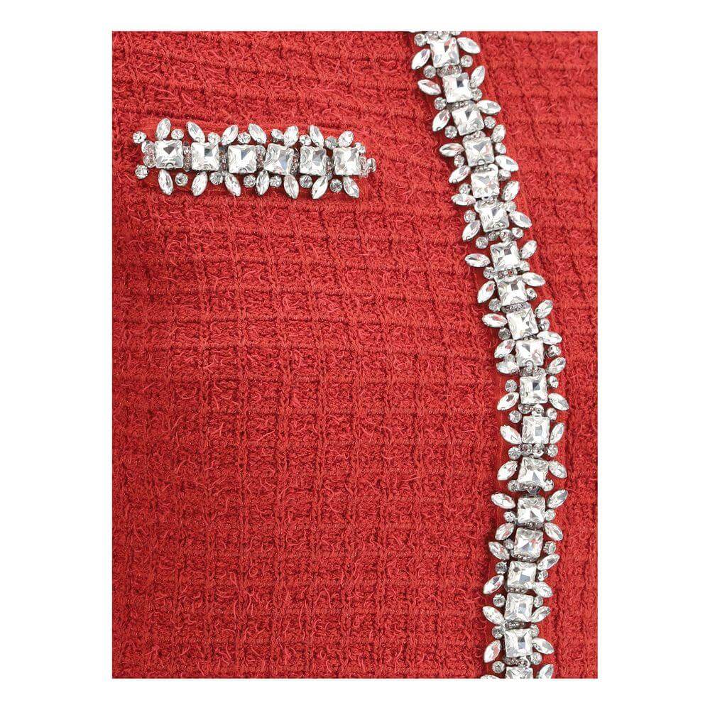 Close-up of a red knit jacket with shiny jewel appliqués on a crewneck and front detailing, showcasing elegance and sophistication.