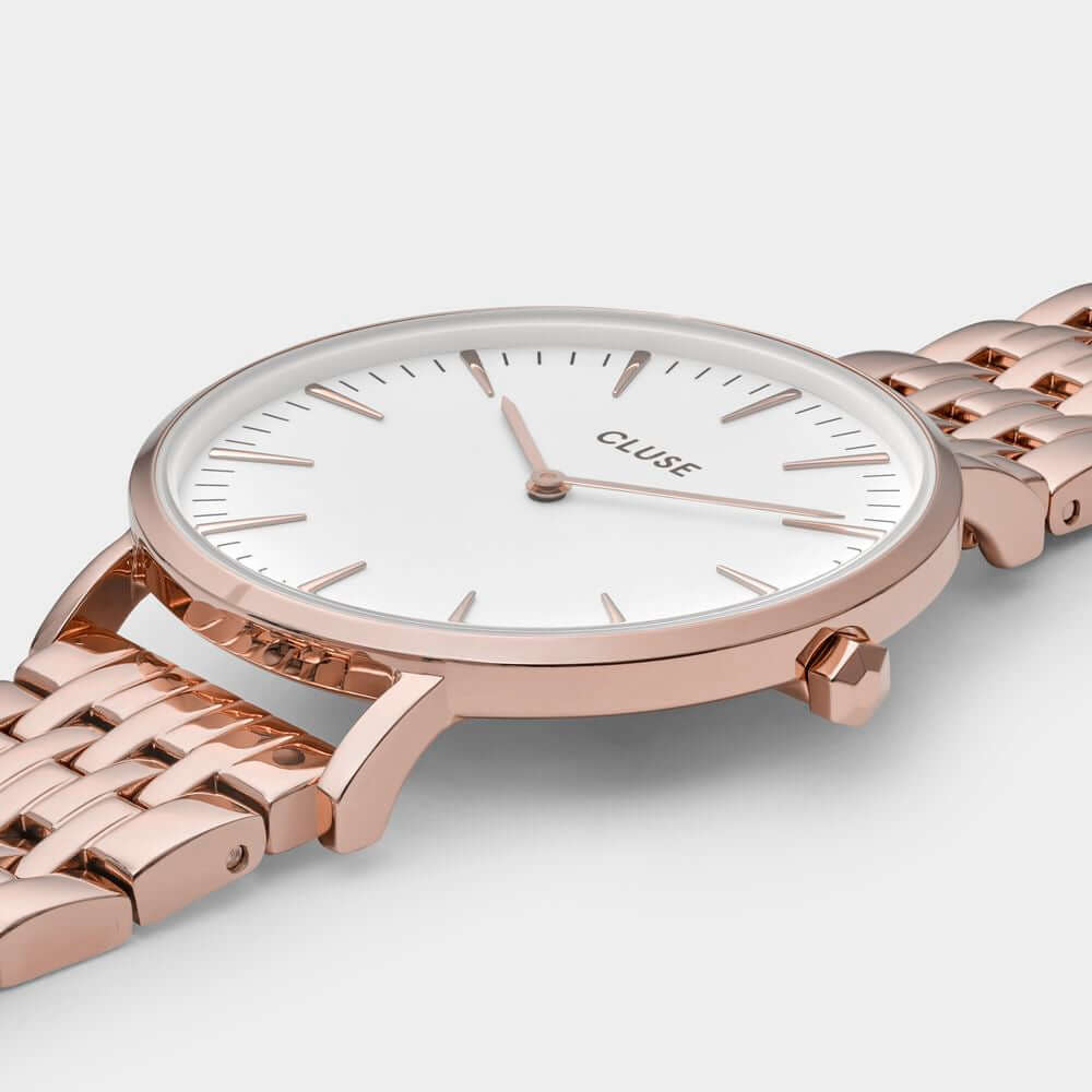 Cluse multicolor quartz watch with pink stainless steel case and bracelet, white dial, and mineral glass, 38mm diameter, 3 ATM water resistance.