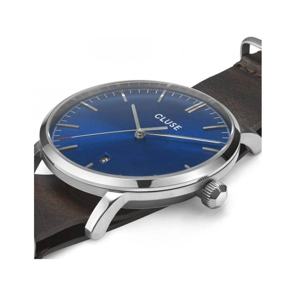 Cluse brown leather watch with blue analog dial, silver stainless steel case, mineral glass, and quartz mechanism, 3 ATM water resistant.