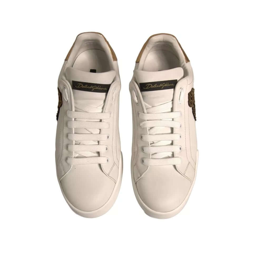 White Dolce & Gabbana Portofino sneakers with crown patch and gold details on tongue. Made of calfskin leather, lace-up style, rubber sole. Model CS1761.