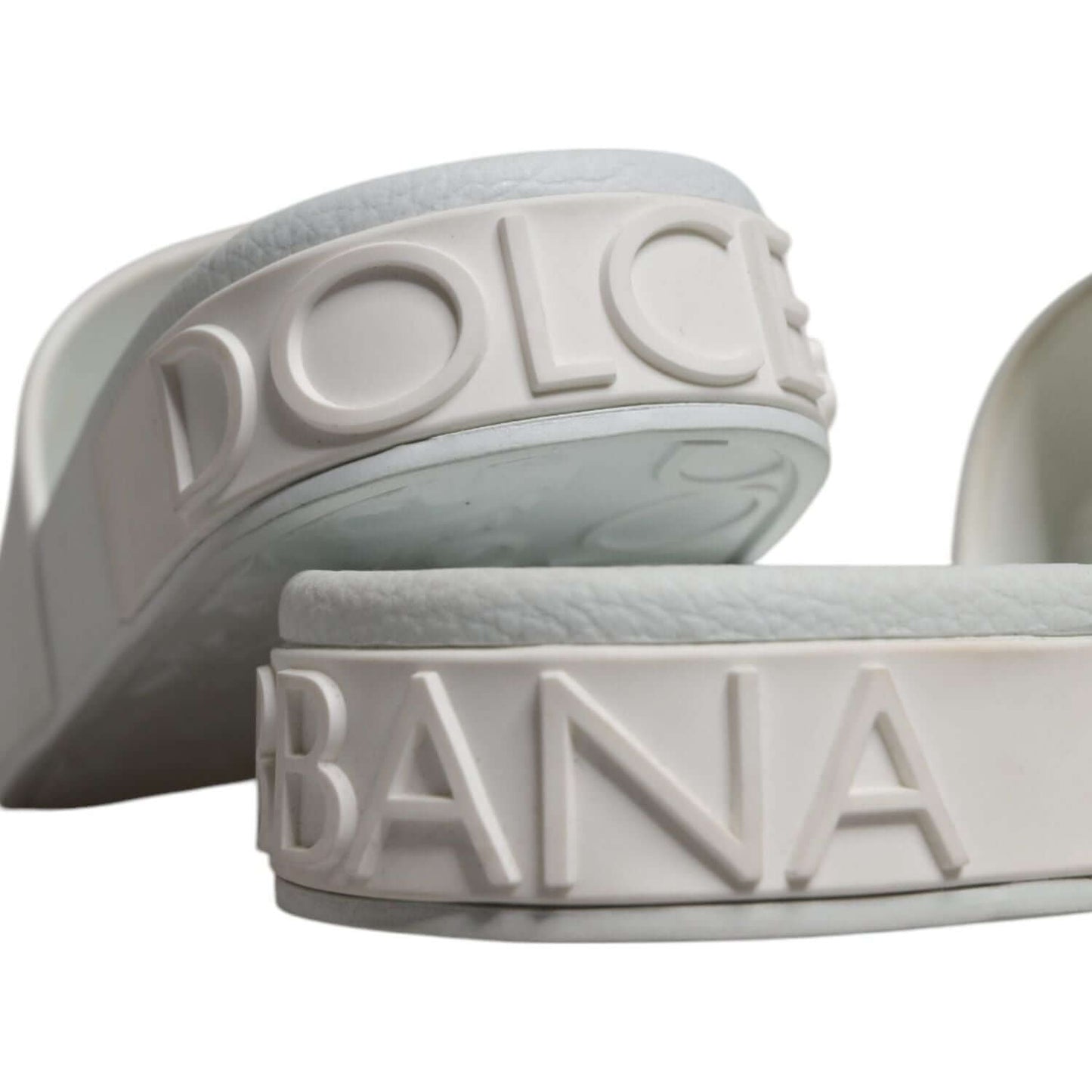 Dolce & Gabbana white rubber slide sandals with embossed logo details on the sole, luxury Italian beachwear footwear.