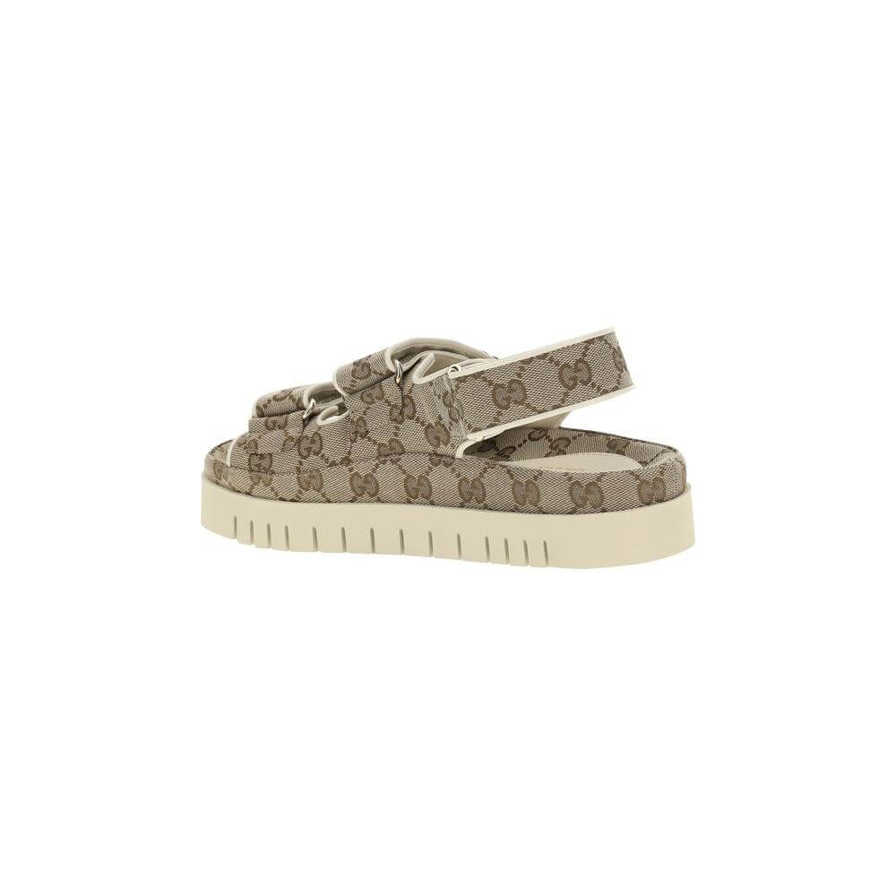 Gucci GG pattern sandals with reinforced rubber sole, two straps, and velcro closure, featuring iconic logo plaque for stylish comfort.