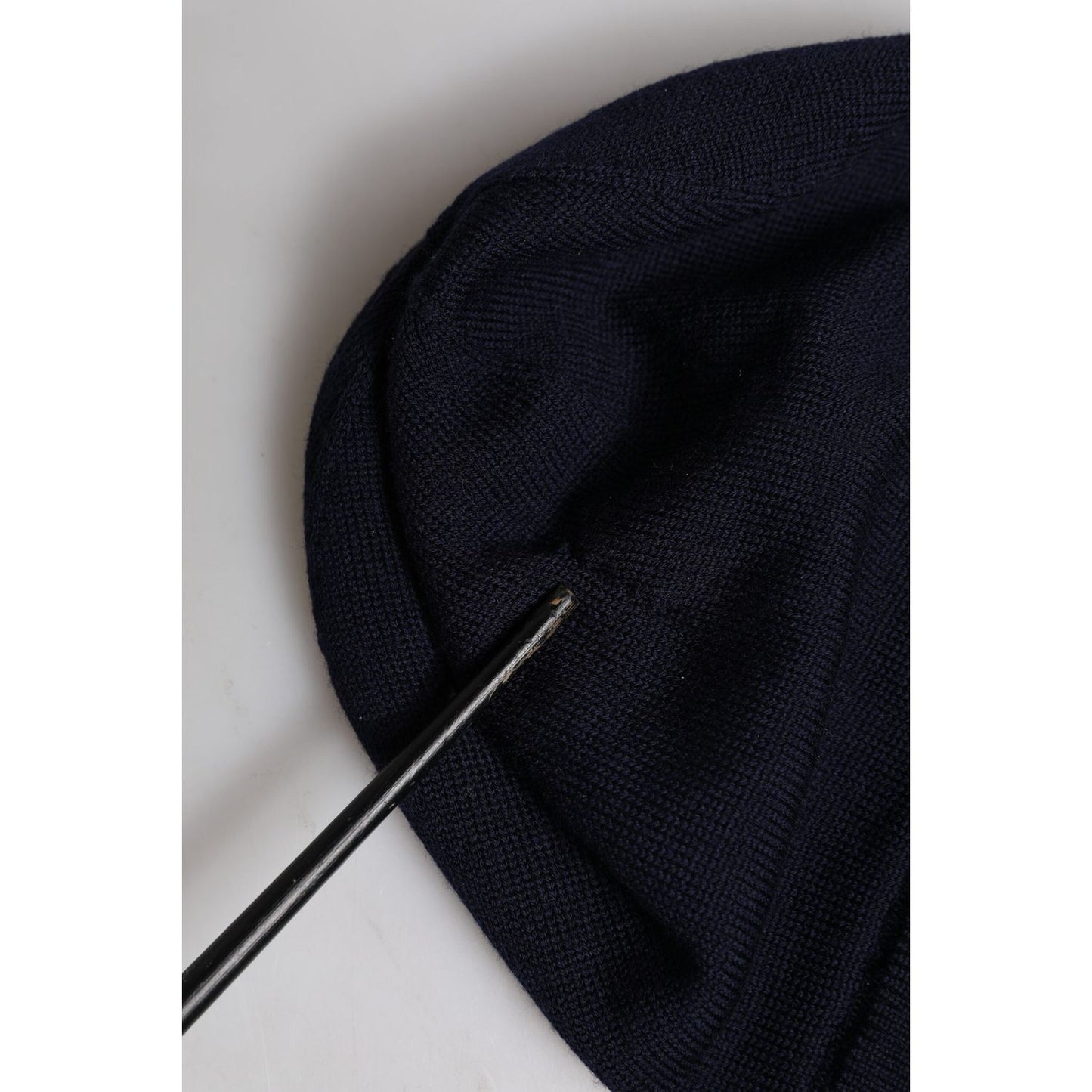 Close-up of black Dolce & Gabbana wool beanie showing repaired rip, #DGLovesLondon embroidery visible.