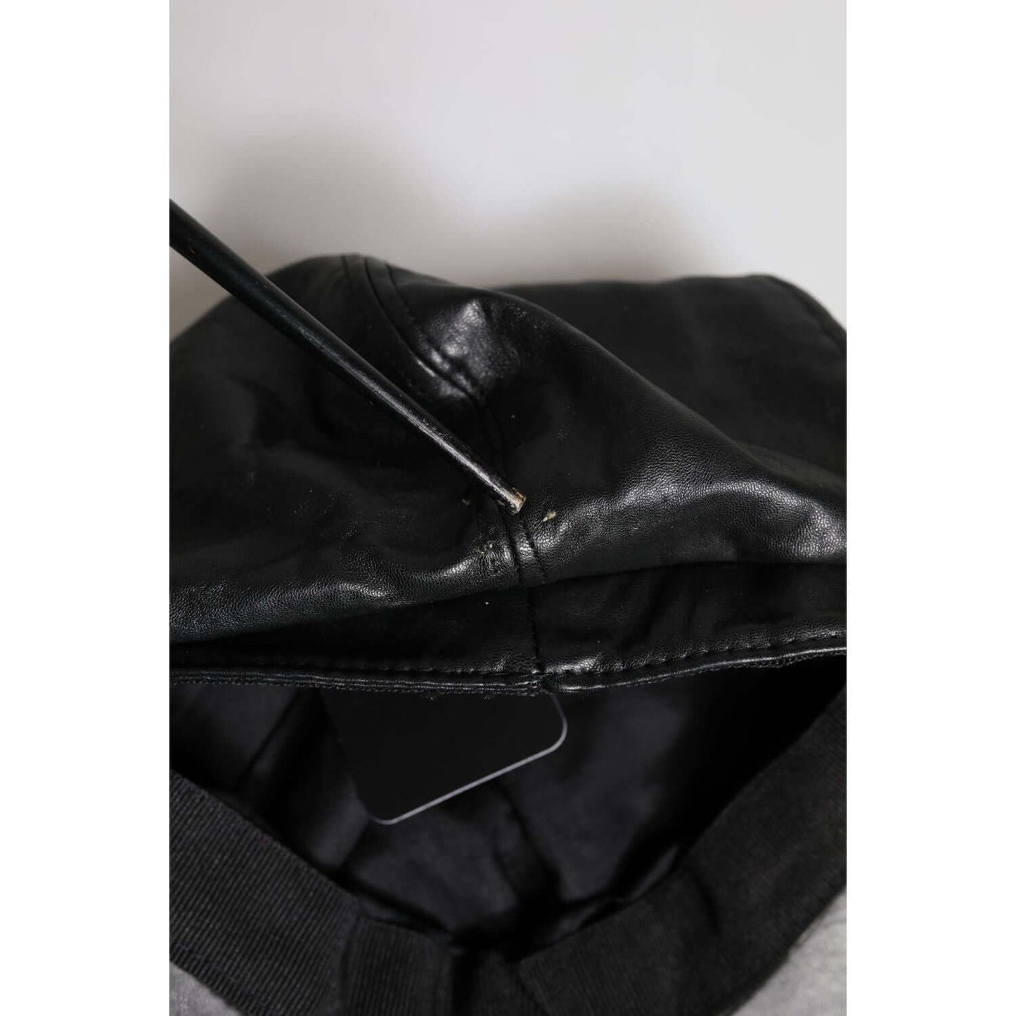 Dolce & Gabbana black leather newsboy hat with minor scratches on back, shown on interior details and tag, high craftsmanship, Made in Italy.