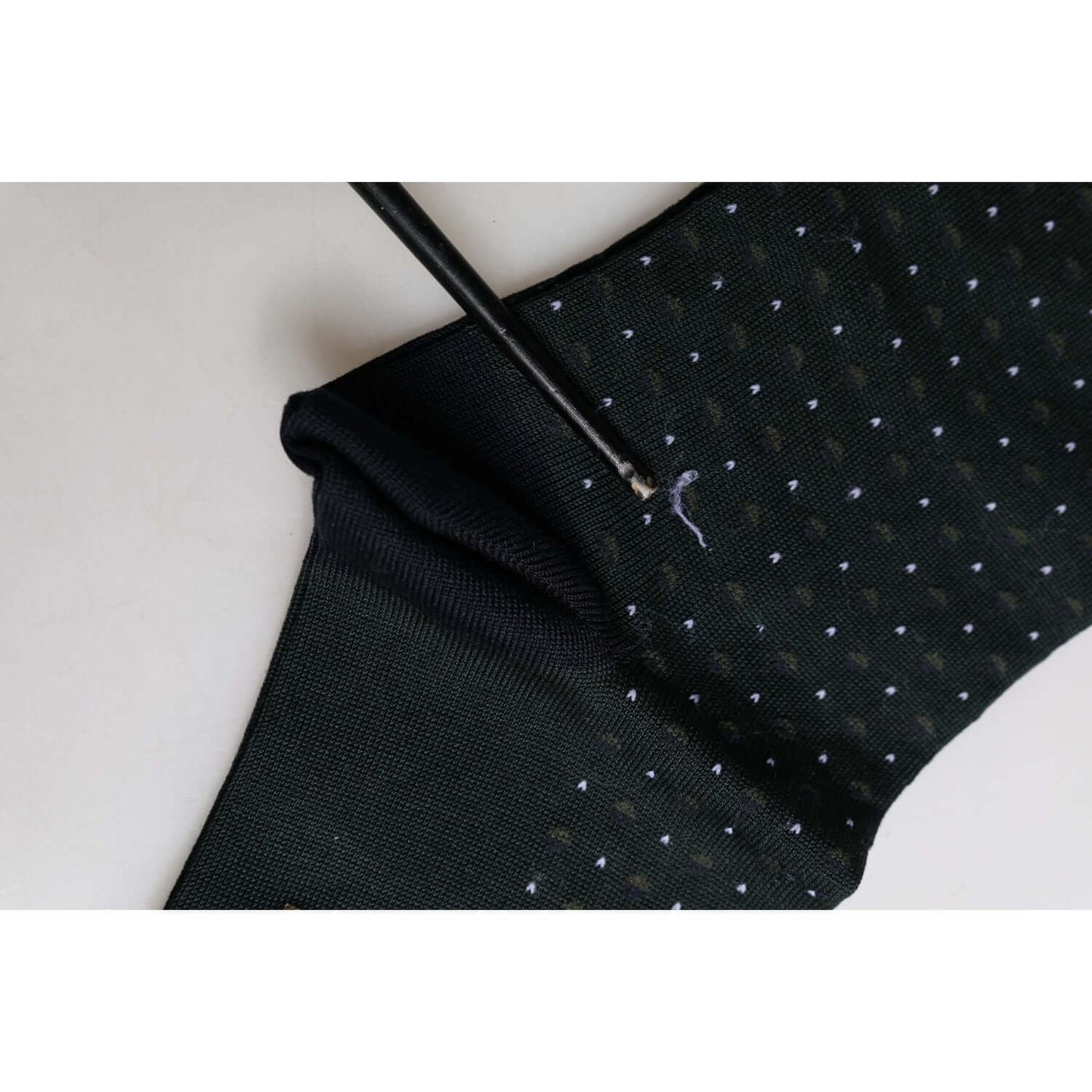 Dolce & Gabbana black polka dot mid calf socks, close-up of minor defect with pulled threads, 80% cotton 20% nylon, made in Italy
