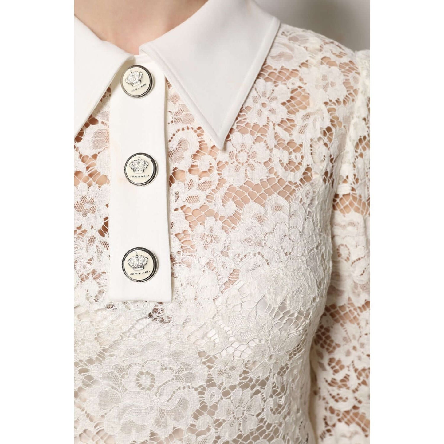 Dolce & Gabbana white floral lace shift dress with long sleeves, featuring logo buttons and a crisp collar, showcasing intricate detailing.