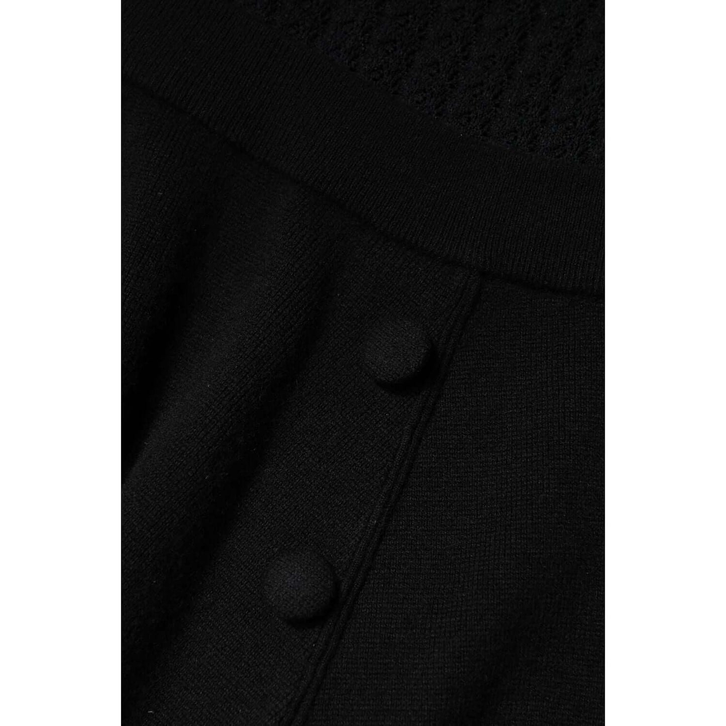 Close-up of black cashmere fabric with button details on a Dolce & Gabbana A-line midi dress, showcasing fine craftsmanship.