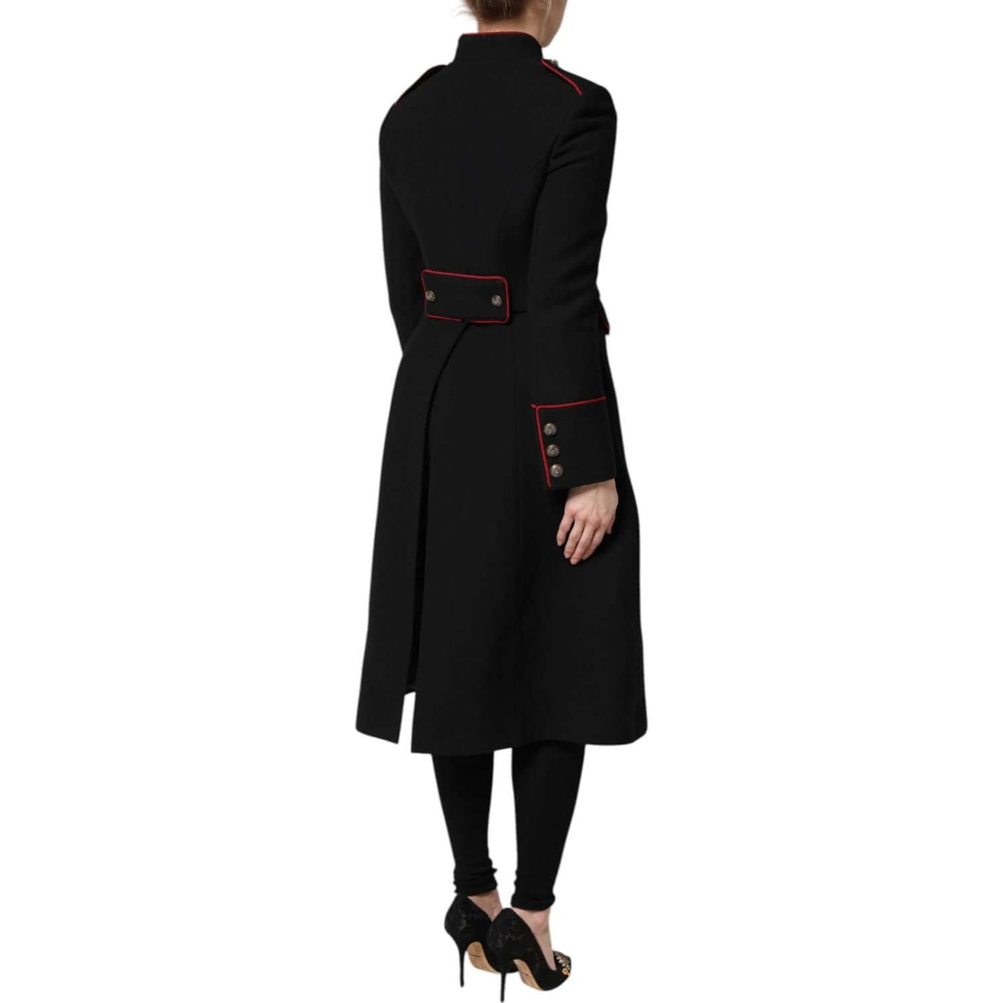 Back view of Dolce & Gabbana black wool single-breasted trench coat with button accents and red piping, worn by a model.