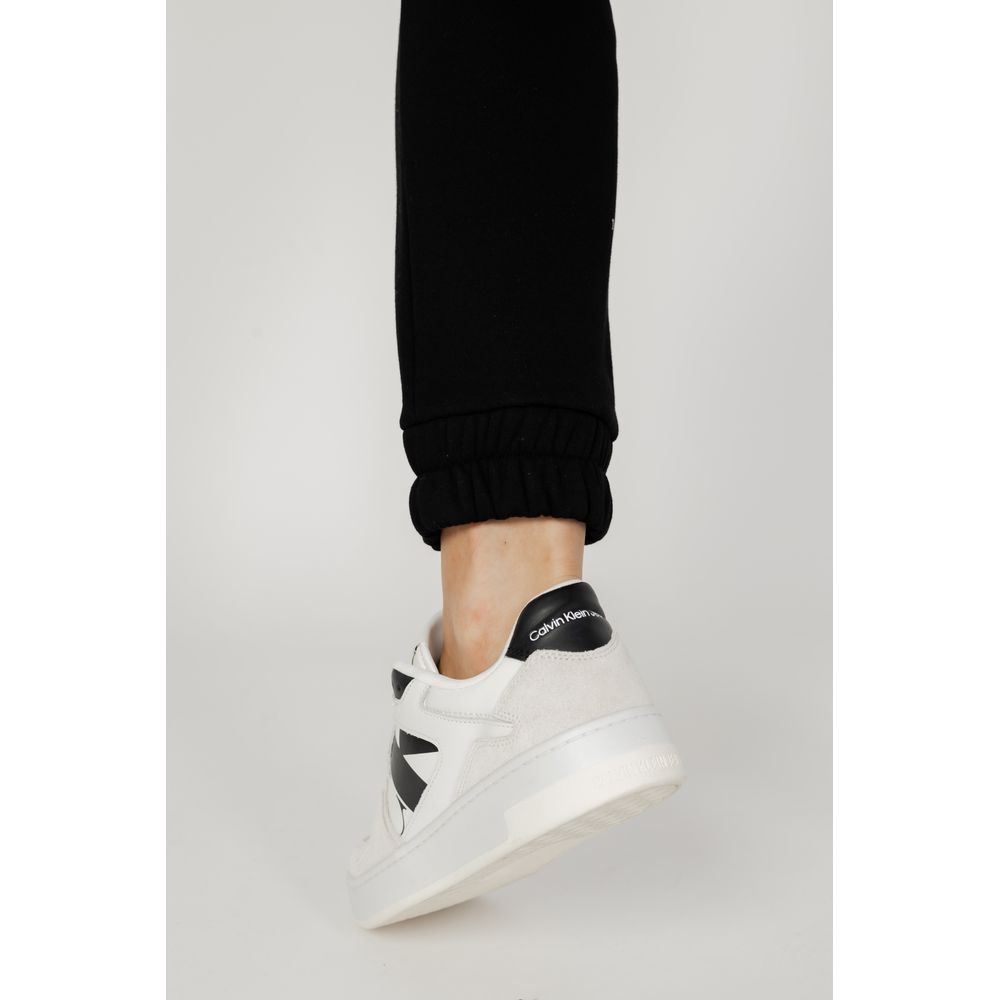 Close-up of leg wearing Blauer Black Cotton Joggers (Workout Pants) with elastic cuff and white sneakers.