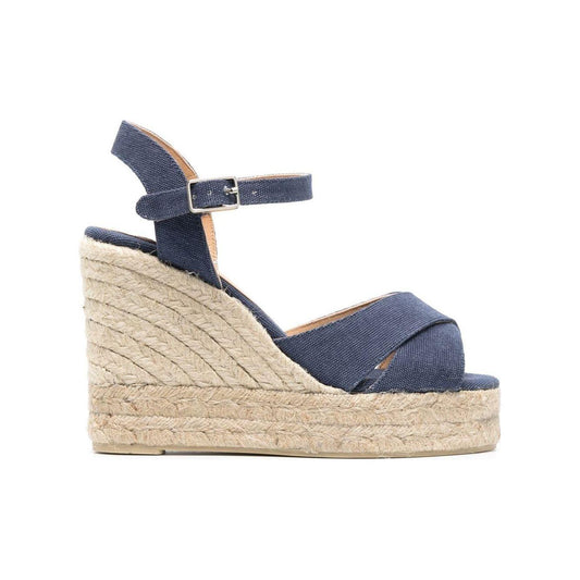 Navy blue Castañer wedge sandals with buckle strap, leather insole, open toe, and raffia platform and heel.
