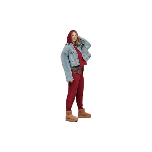 Woman wearing UGG beige suede leather boots, red outfit, and denim jacket.