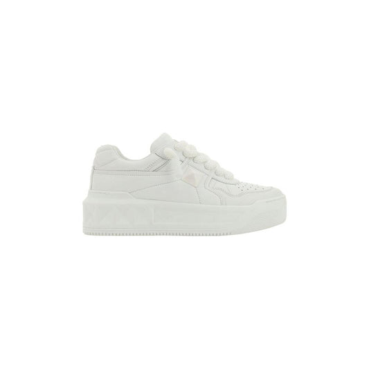 Valentino Garavani white leather sneakers with round toe, flat sole, lace-up closure, branded tab, and stud embossed details on side panel.