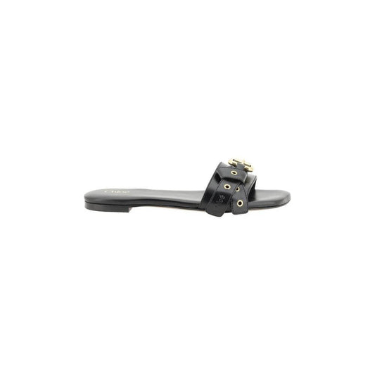 Alt Tag: Chloé Mae Sandals in black leather with knotted straps, gold eyelets, and Paddington buckle on a flat sole.