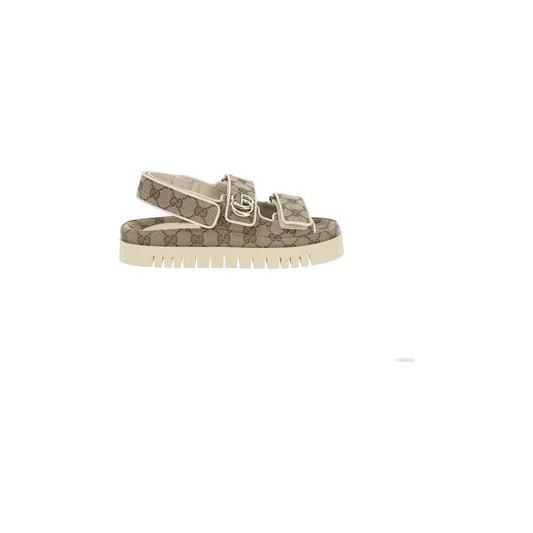 Gucci GG pattern sandals with rubber sole, Velcro closure, and logo plaque, offering comfort and style in a trendy design.