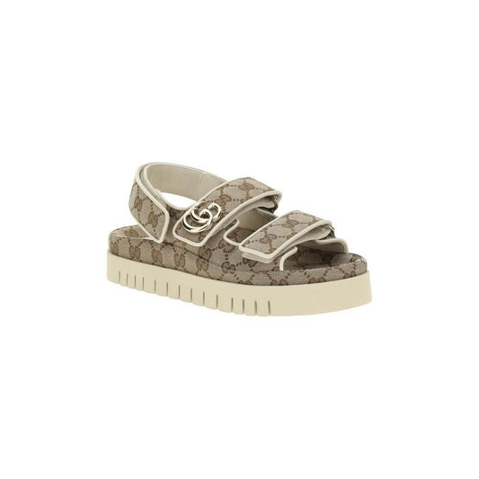 Gucci GG pattern sandals with high rubber sole, double straps, Velcro closure, and logo plaque for casual style and comfort.