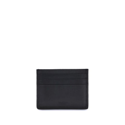 Ferragamo Black Calf Leather Bos Taurus Wallet with card slots and palladium Gancini ornament on black background.