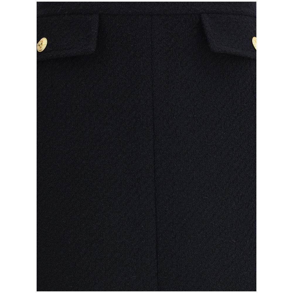 Close-up of Chloé Black Wool Midi Skirt with gold-tone button accents on front flap pockets, highlighting the premium bouclé wool texture.