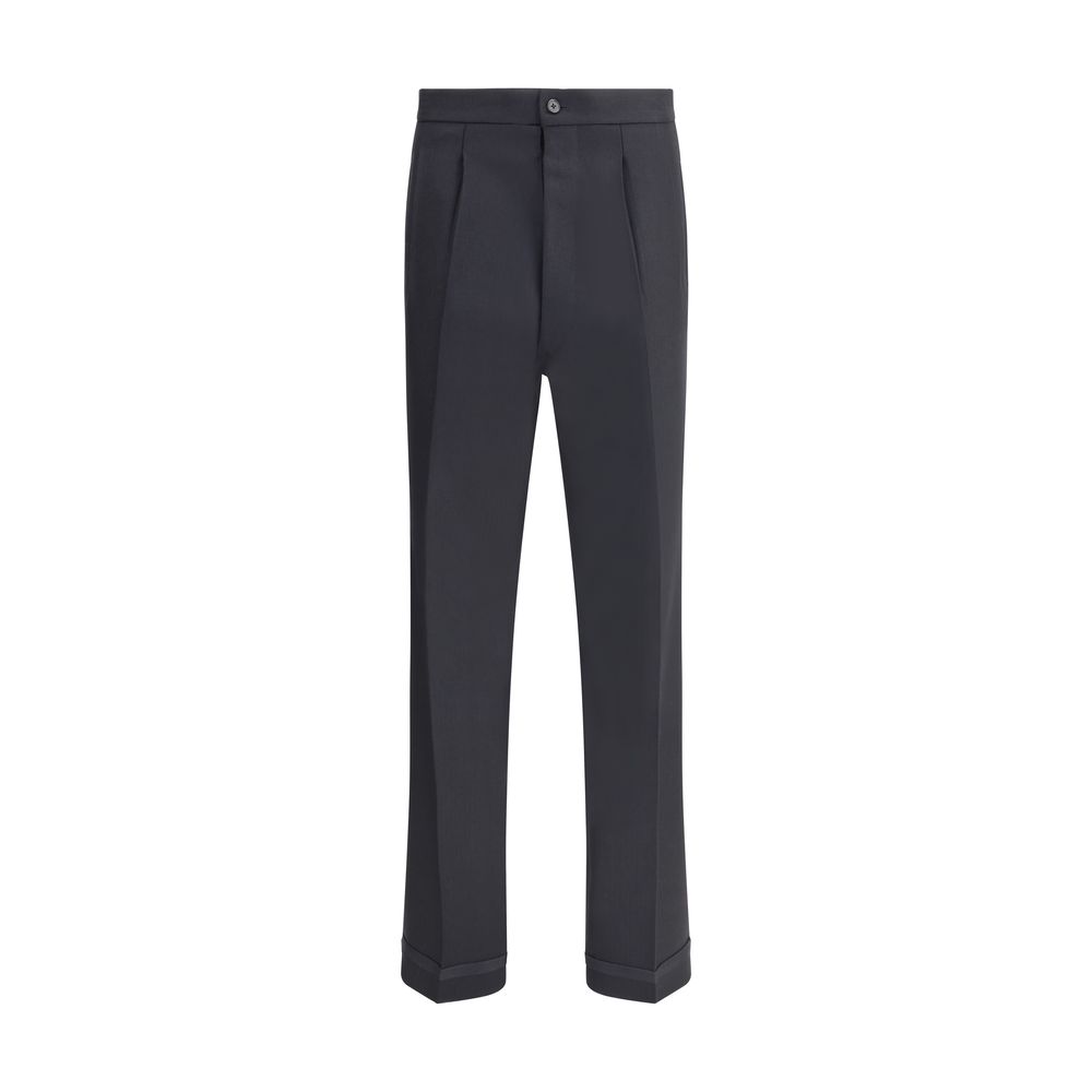 Margiela Black Wool Dress Pants with pleated front, turn-ups, and logo closure, featuring welt pockets and iconic topstitching detail.