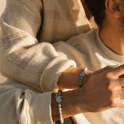 Couple wearing matching bracelets, showcasing AN JEWELS JEWELRY Mod. ADC.BWGLB02S in a warm embrace.