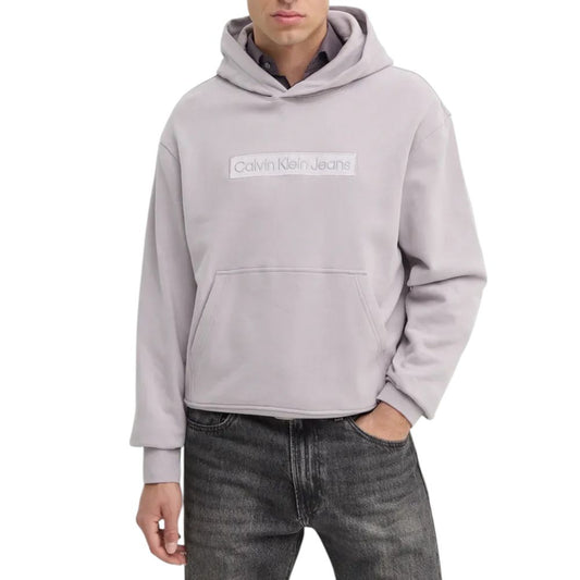 Man wearing Calvin Klein Jeans Purple Cotton Hoody with embroidered logo, paired with jeans for a casual look.