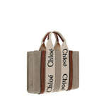 Chloé Woody Handbag with canvas body, leather trim, and brand logo, featuring flat handles and removable strap. Made in Italy.