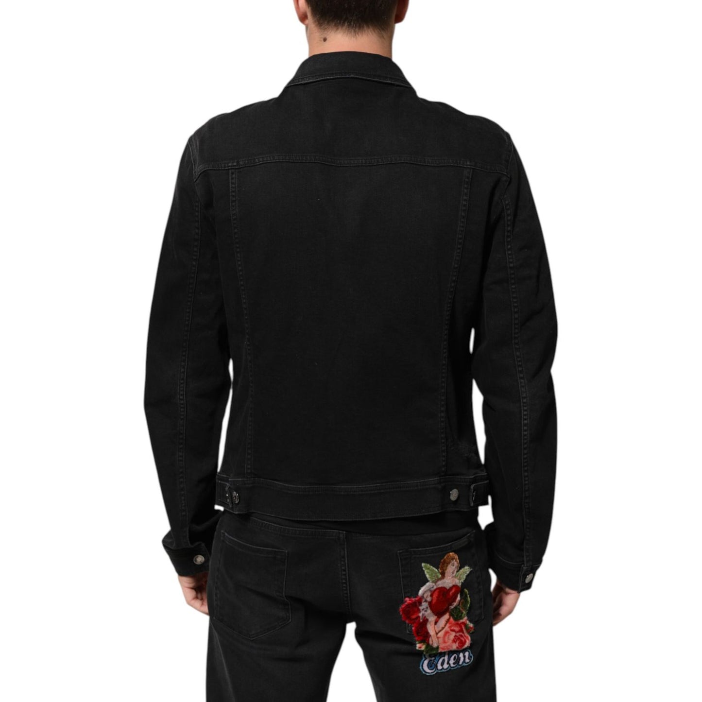 Back view of Dolce & Gabbana Black Cotton Denim Stretch Button Up Jacket with floral embroidery on black jeans