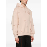 Man wearing Emporio Armani Sweaters Powder blush pink hoodie with logo, featuring drop shoulder, ribbed cuffs, and hem, organic cotton.