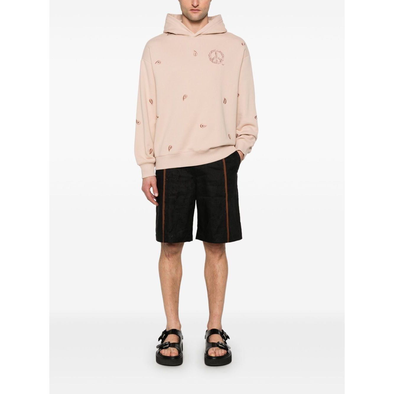 Model wearing blush pink Emporio Armani Sweaters Powder hoodie with drop shoulders and ribbed cuffs, paired with black shorts.
