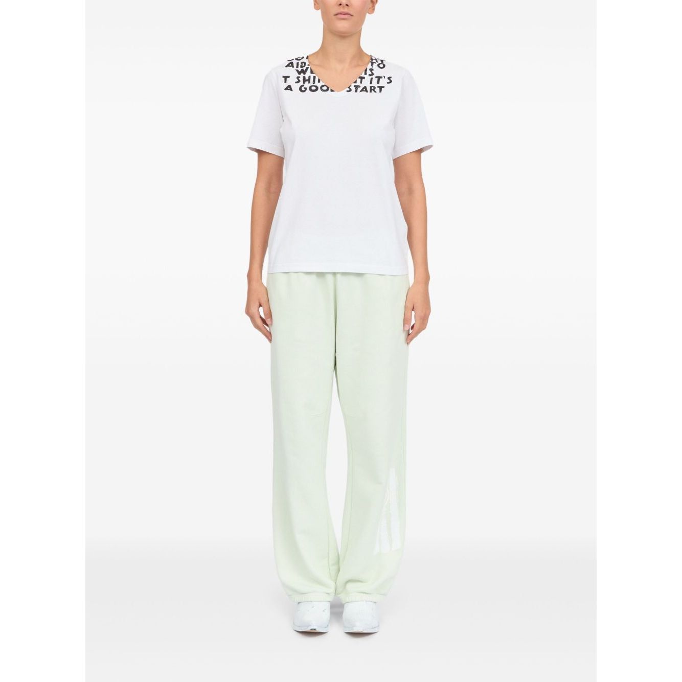 Model wearing MM6 Maison Margiela T-shirts and Polos White, showcasing front graphic print, V-neck, and short sleeves.