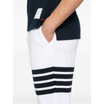 Side view of Thom Browne Trousers White with elasticated drawstring waistband, side slit pockets, and signature 4Bar cotton design.