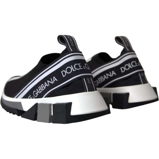 Dolce & Gabbana black and white Sorrento slip-on sneakers with logo print, rubber sole, and fabric pull strap, rear view.